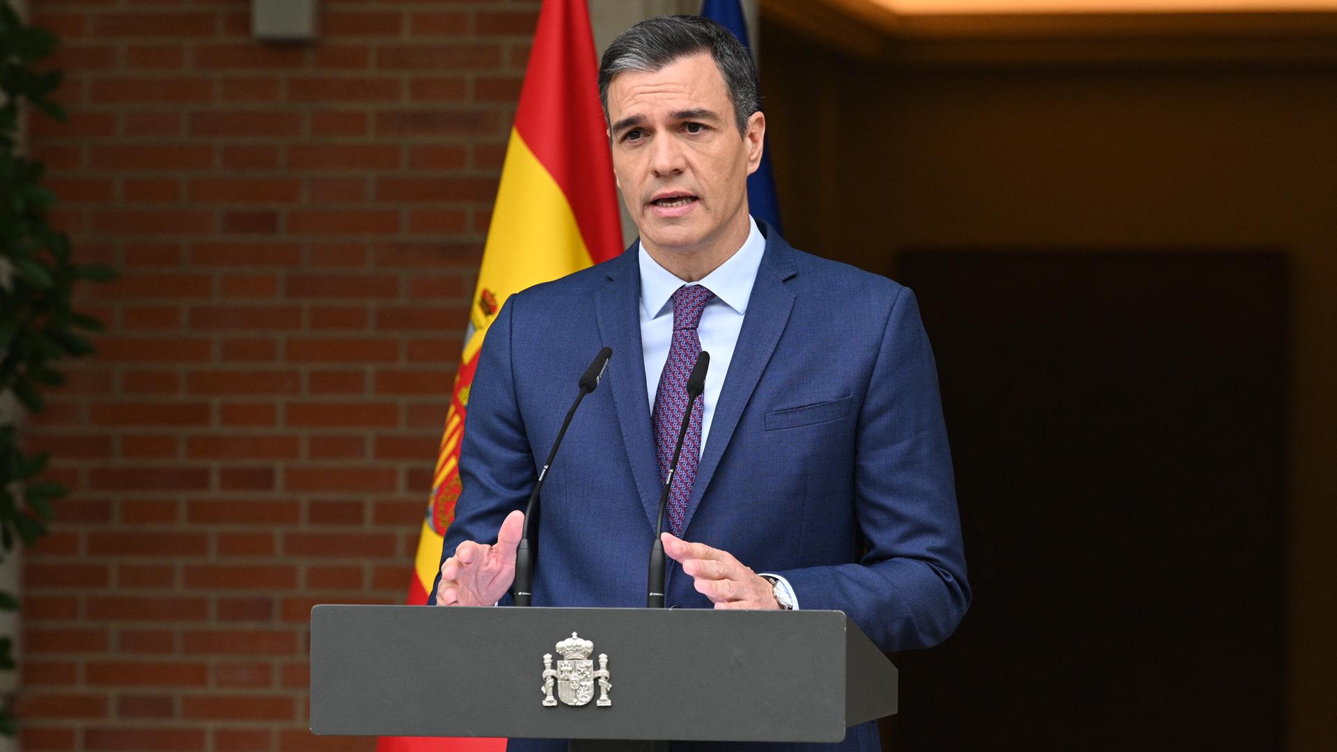 Der spanische Premier Pedro Sanchez steht an einem Rednerpult. Im Hintergrund die spanische Flagge.