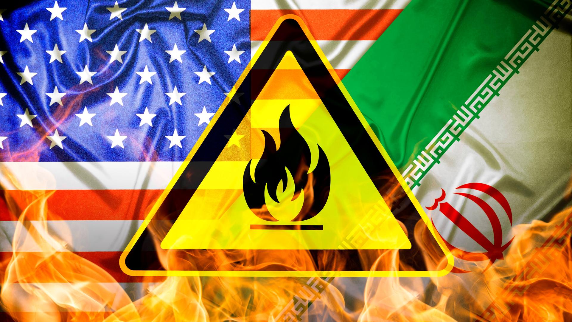 Das Bild zeigt eine Kombo aus den Flaggen der USA und des Iran, unter denen Flammen zu sehen sind. Davor montiert ist ein gelb-schwarzes Gefährdungszeichen. Das Bild zeigt eine Kombo aus den Flaggen der USA und des Iran, unter denen Flammen zu sehen sind. Davor montiert ist ein gelb-schwarzes Gefährdungszeichen.