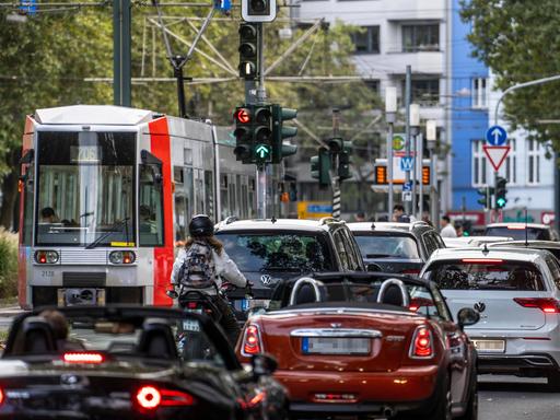 Viele Autos und eine Straßenbahn auf einer Straße in einer Stadt 