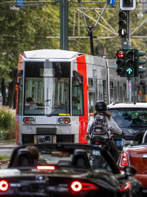 Viele Autos und eine Straßenbahn auf einer Straße in einer Stadt 