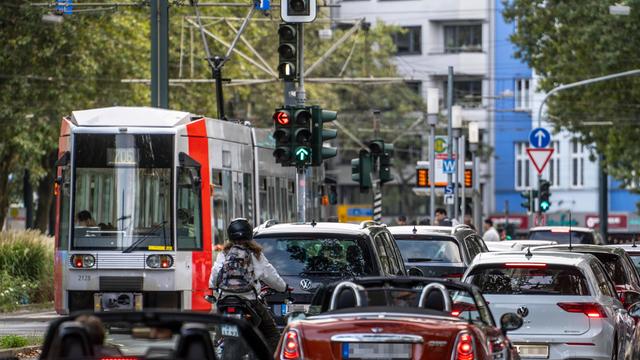 Viele Autos und eine Straßenbahn auf einer Straße in einer Stadt 