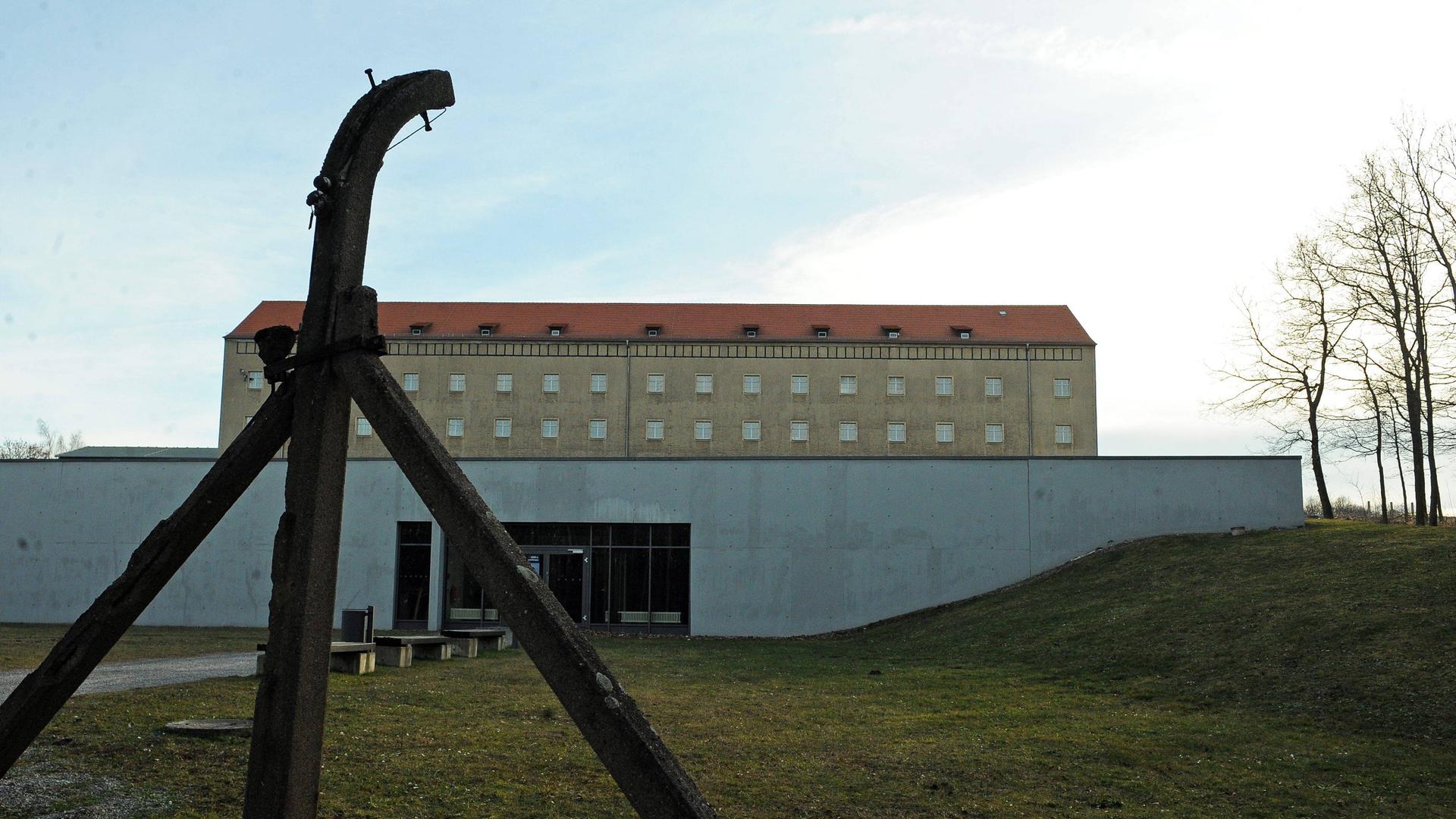 Das Bild zeigt das ehemalige sowjetische Speziallager Nr.2 in Buchenwald. Ein mehrstöckiges Gebäude, davor Rasen und die Pfosten eines Zauns.