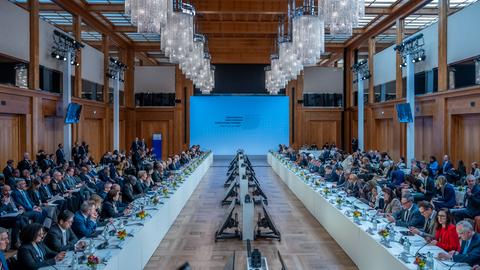 Mehrere Personen sitzen sich an zwei langen Tischen an der Internationalen Sudan-Konferenz im Auswärtigen Amt gegenüber. 