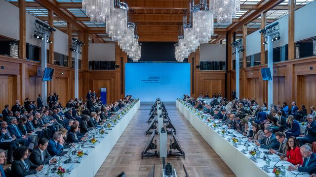 Mehrere Personen sitzen sich an zwei langen Tischen an der Internationalen Sudan-Konferenz im Auswärtigen Amt gegenüber. 