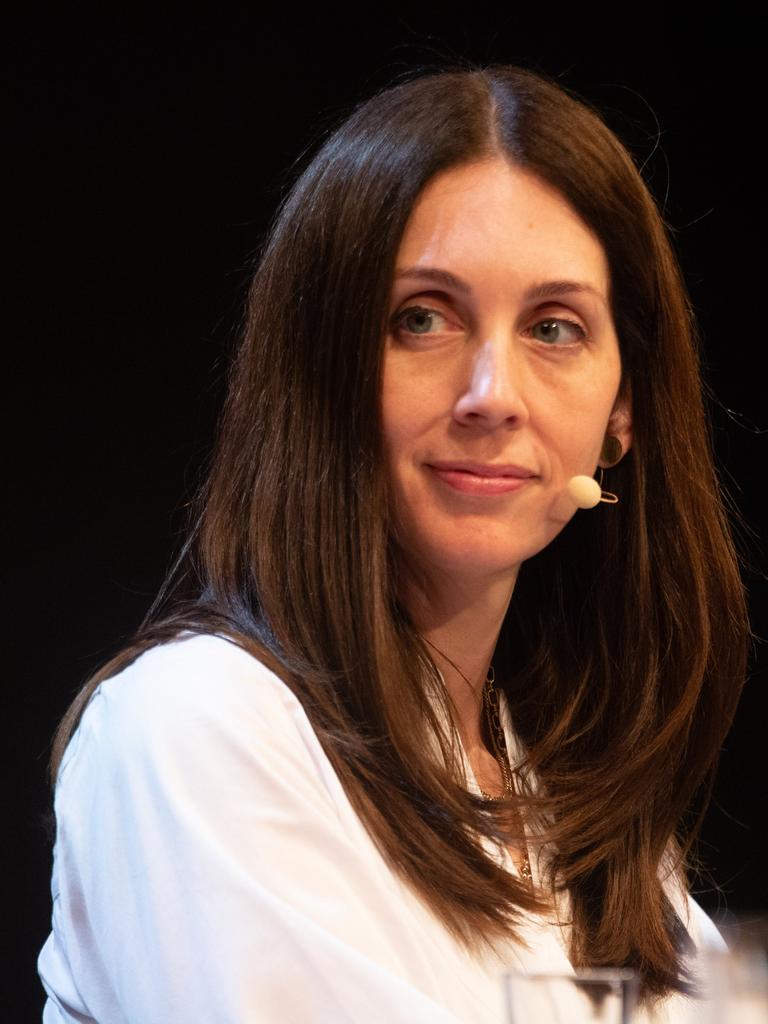 Eine Frau sitzt auf einer Bühne und blickt nach links. Es ist die US-Autorin Liz Moore. Sie hat braune lange Haare und trägt eine weiße Bluse. 