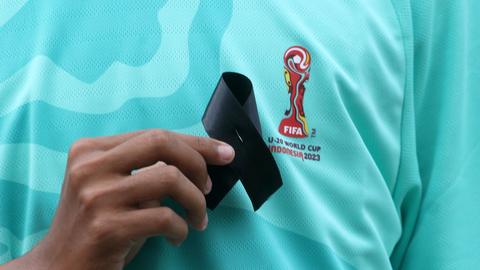 Ein Aktivist in Jakarta (Indonesien) hält nach dem Entzug der U20-WM durch die FIFA ein schwarzes Trauer-Bändchen vor die Brust.