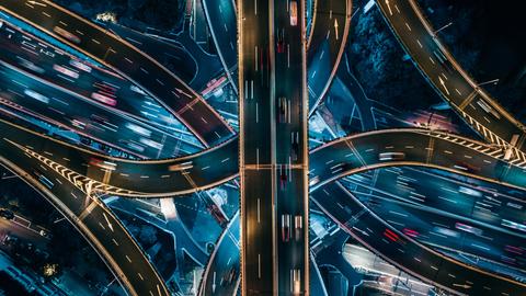 Luftaufnahme sich kreuzender Autobahnstrecken bei Nacht.