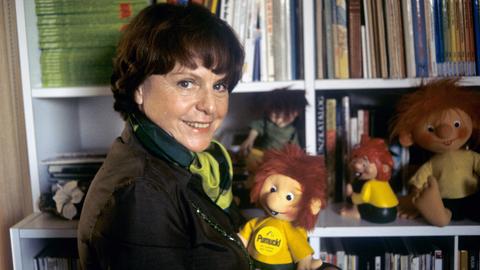 Die Kinderbuchautorin und Erfinderin der Zeichentrickfigur "Pumuckl", Ellis Kaut, in ihrer Wohnung in München mit einigen Pumuckl-Puppen vor ihrem Bücherregal.