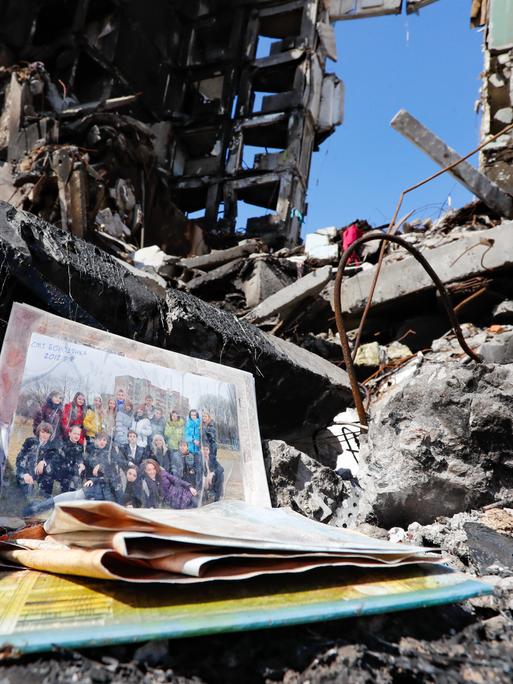 Ein privates Klassenfoto mit vielen lächelnden Menschen liegt in einer im Krieg zerstörten Häuserruine in Butscha, Ukraine, am 7. April 2022.