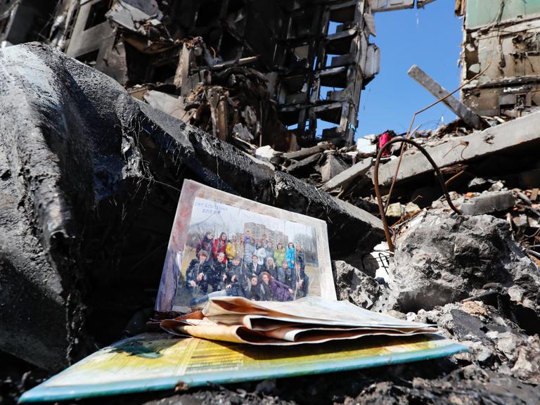 Ein privates Klassenfoto mit vielen lächelnden Menschen liegt in einer im Krieg zerstörten Häuserruine in Butscha, Ukraine, am 7. April 2022.