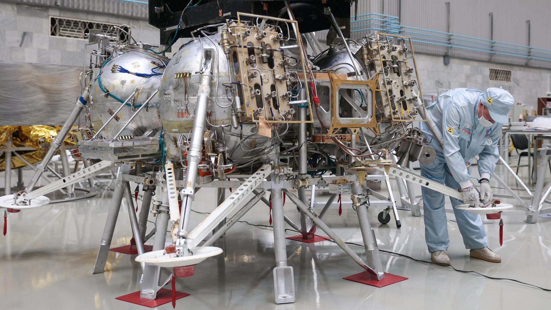Ein Angestellter der S.A. Lawotschkin Forschungs- und Produktionsvereinigung, einem russischen Luft- und Raumfahrtunternehmen, arbeitet an der Luna-25-Mondlandefähre.
