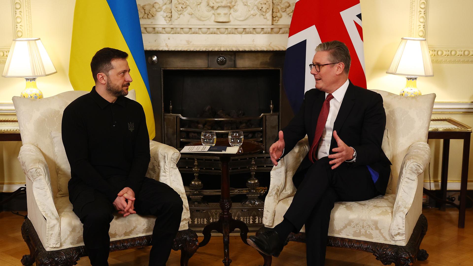 Der ukrainische Präsident Selenskyj sitzt neben dem britischen Premier Starmer auf Sesseln.