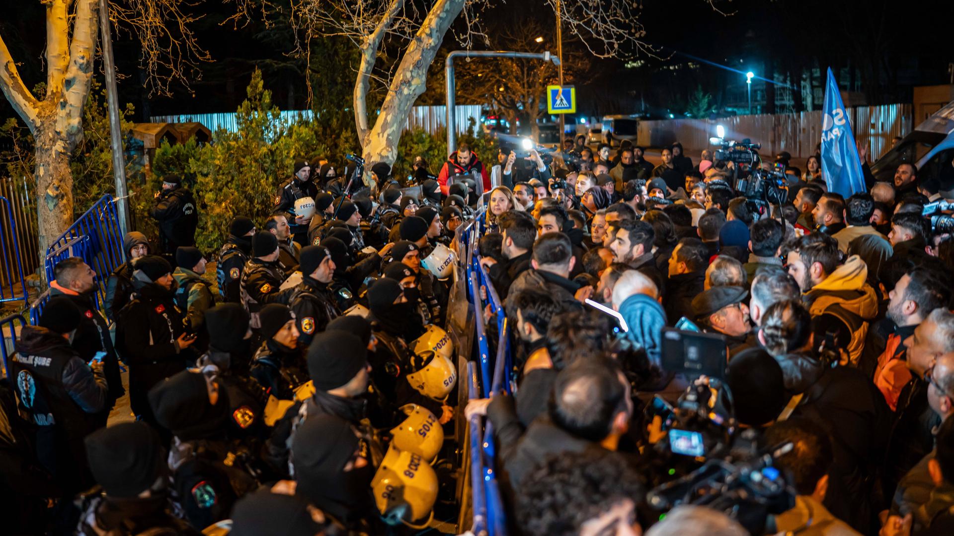 Eine Menschenmenge steht in Ankara vor einer Absperrung, hinter der sich Polizisten befinden. Eine Menschenmenge steht in Ankara vor einer Absperrung, hinter der sich Polizisten befinden.
