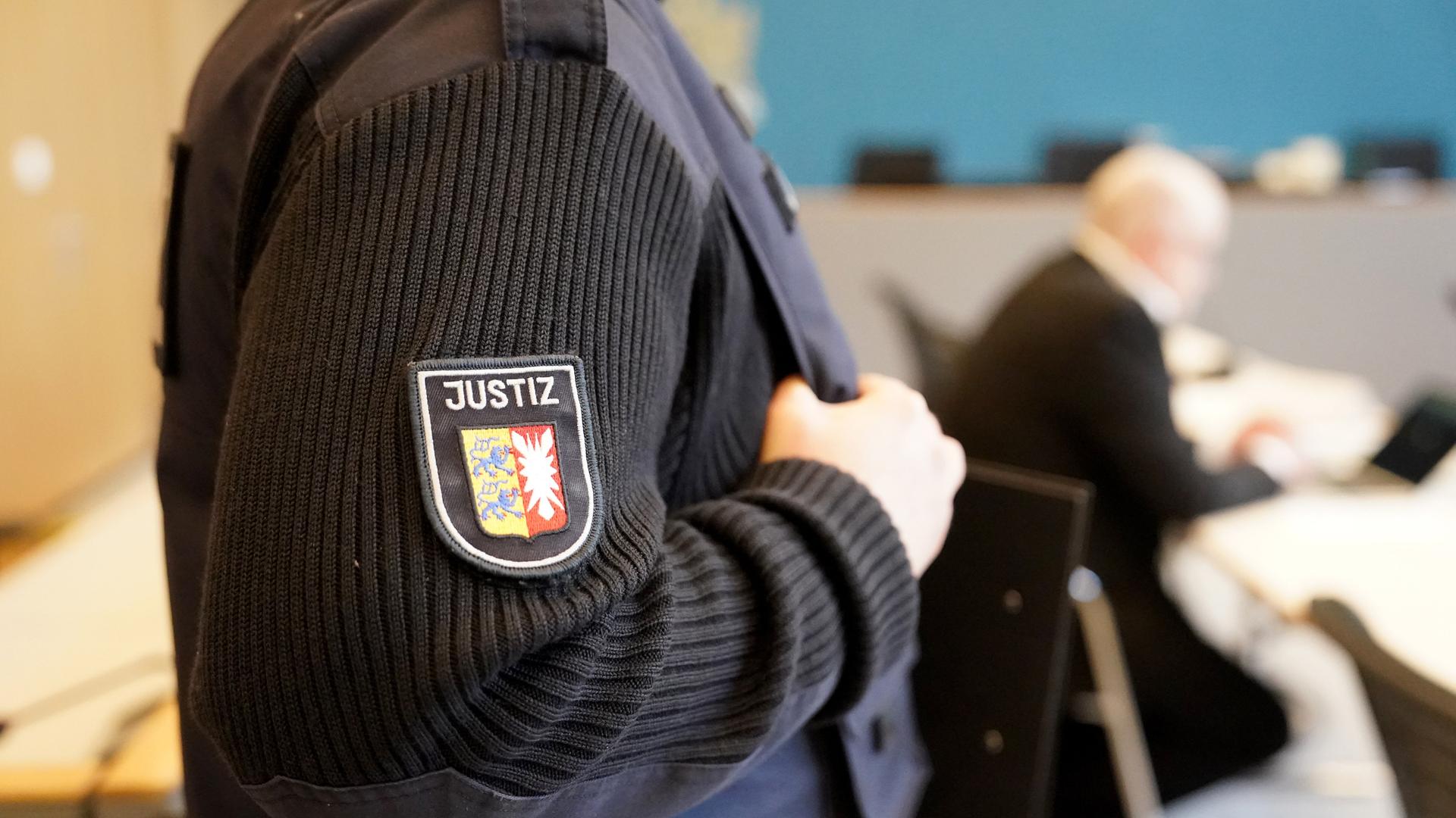 Der Angeklagte sitzt vor Beginn des Prozesses wegen schweren sexuellen Missbrauchs eines Kindes im Sitzungssaal im Landgericht Lübeck. Sein Gesicht ist verpixelt. Im Vorgergrund steht ein Sicherheitsbeamter. Der Angeklagte sitzt vor Beginn des Prozesses wegen schweren sexuellen Missbrauchs eines Kindes im Sitzungssaal im Landgericht Lübeck. Sein Gesicht ist verpixelt. Im Vorgergrund steht ein Sicherheitsbeamter.