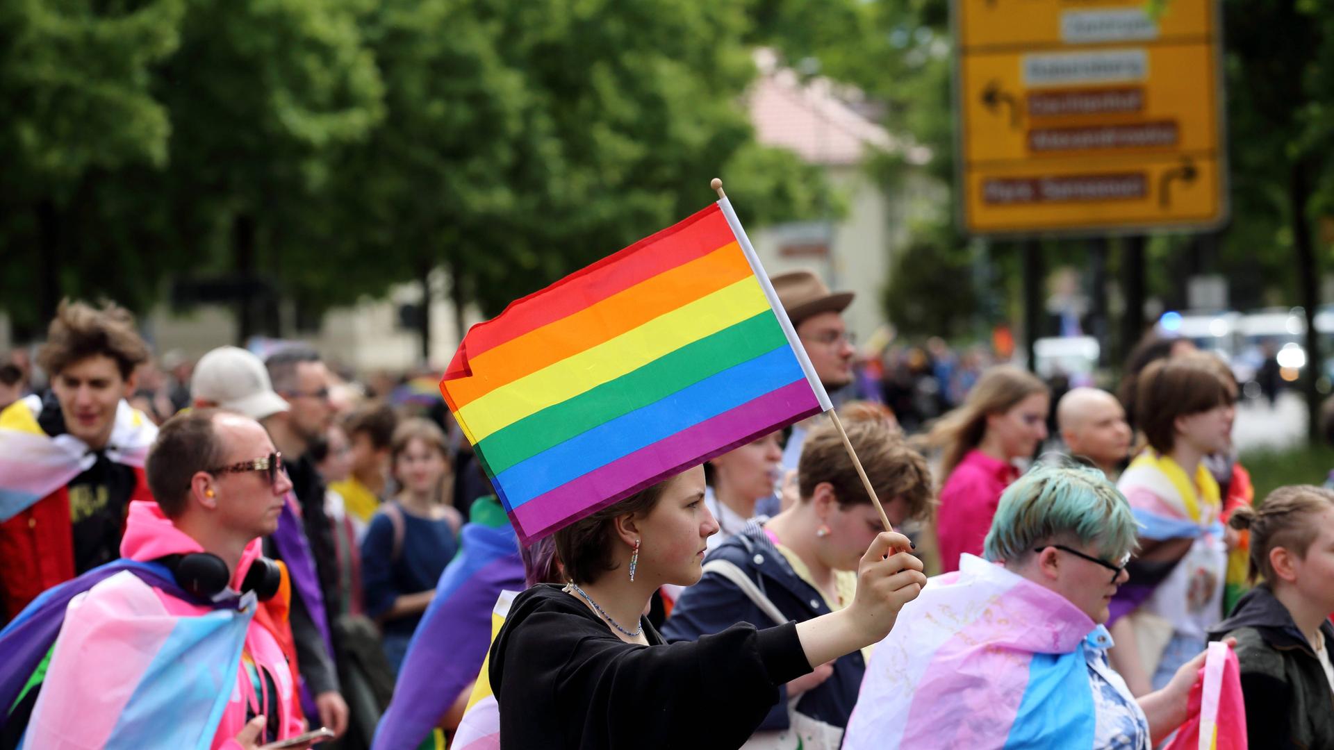 Menschen laufen mit Regenbogenfahne in Pappelallee während einer Demo zum Christopher Street Day in Potsdam, 17. Mai 2025.