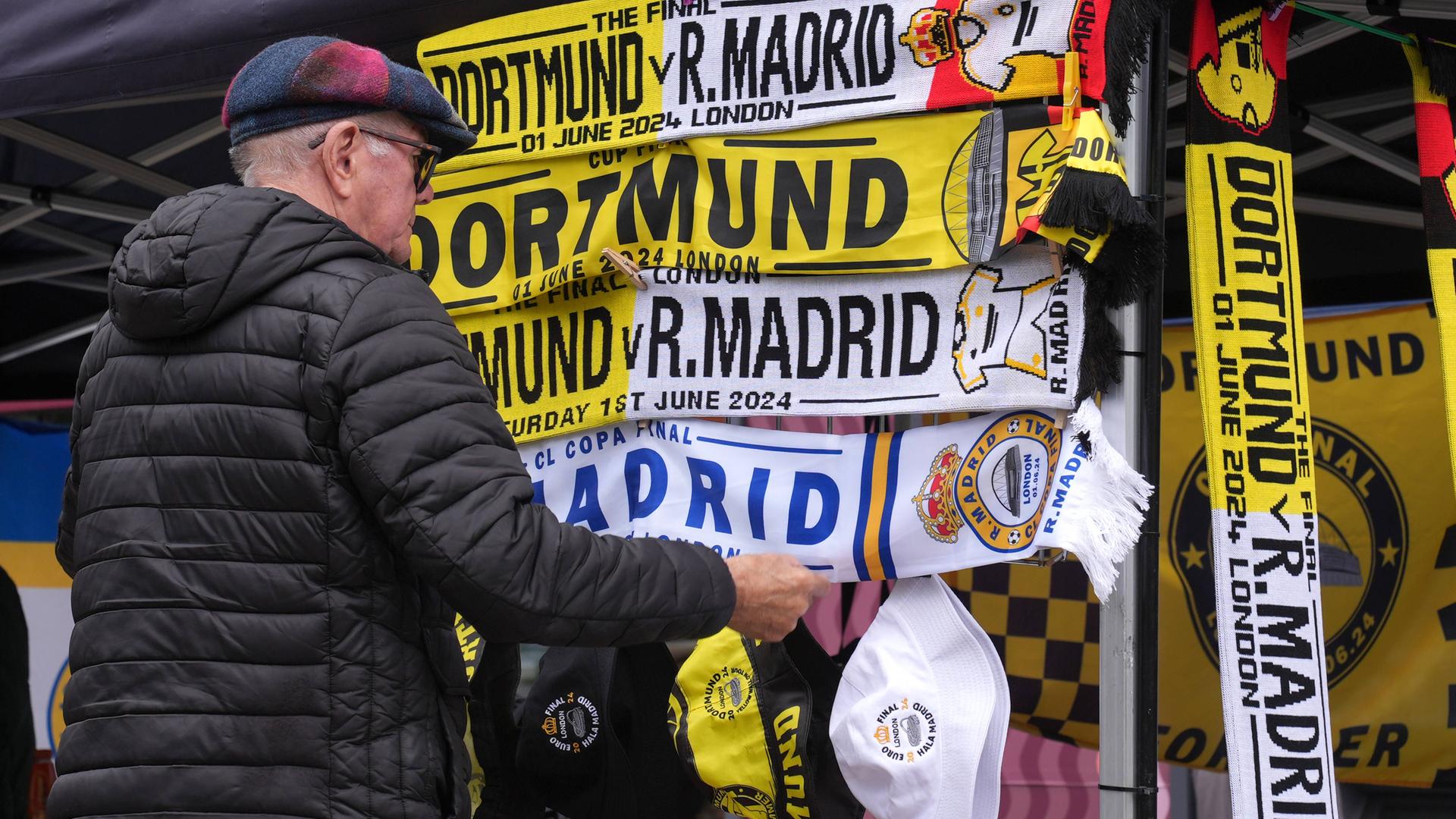 Ein Mann schaut sich Fanschals vor dem Spiel zwischen Borussia Dortmund und Real Madrid an.
