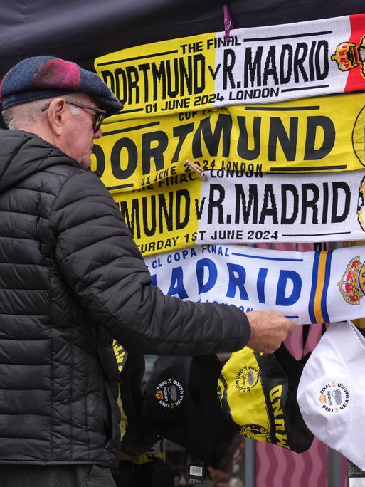 Ein Mann schaut sich Fanschals vor dem Spiel zwischen Borussia Dortmund und Real Madrid an.