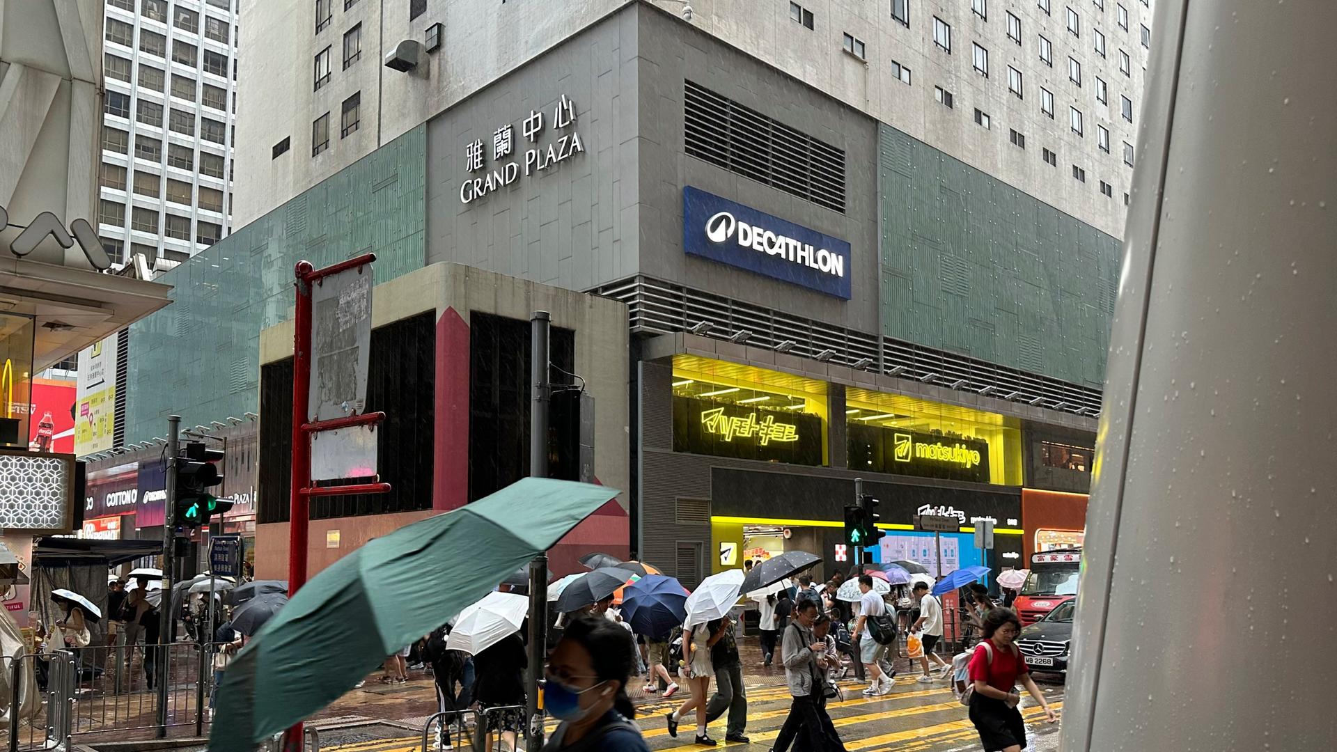 Kurz vor dem Eintreffen von Taifun "Noul" sind Passanten im Hongkonger Stadtteil Mong Kok bei starkem Regen und Wind unterwegs.