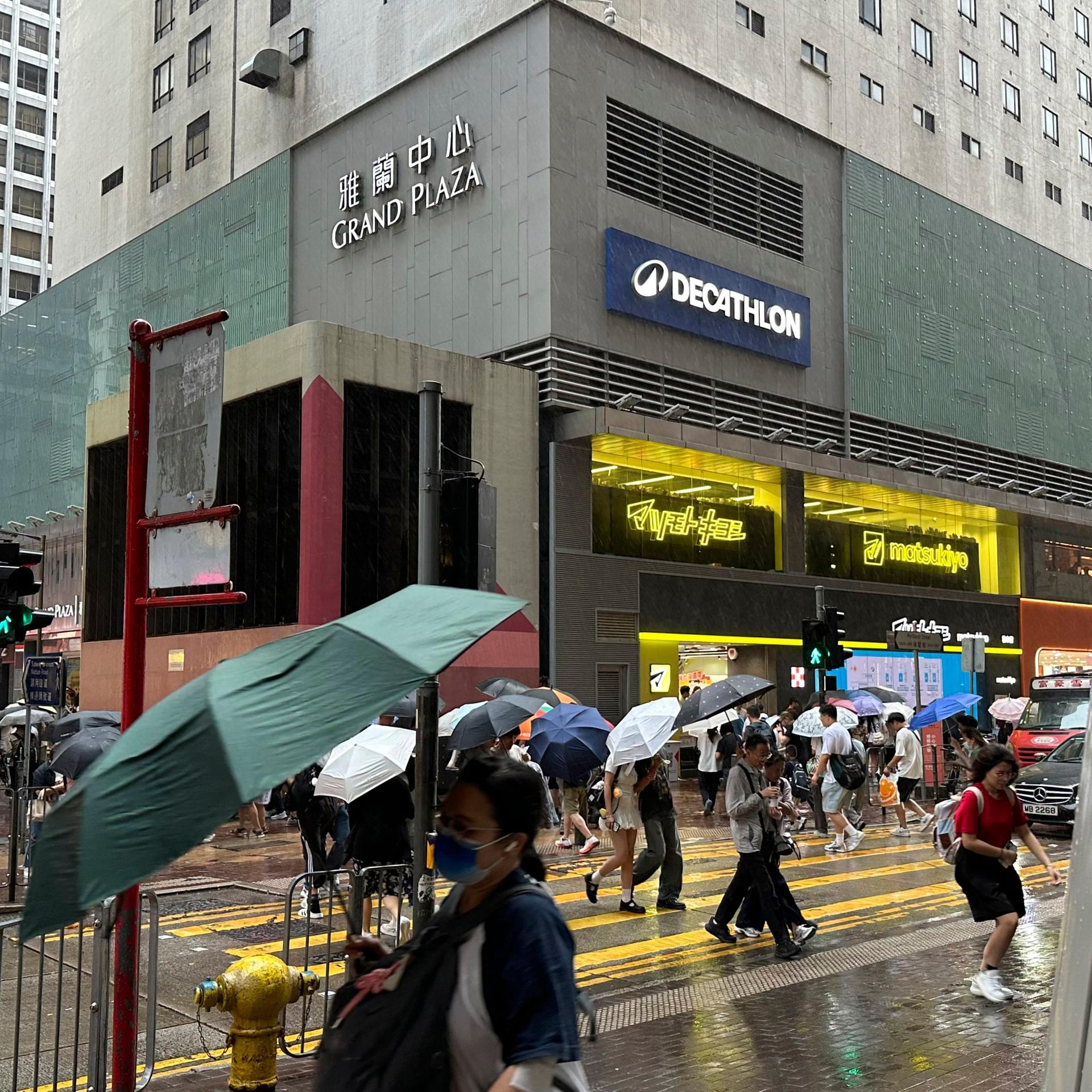Kurz vor dem Eintreffen von Taifun "Noul" sind Passanten im Hongkonger Stadtteil Mong Kok bei starkem Regen und Wind unterwegs.