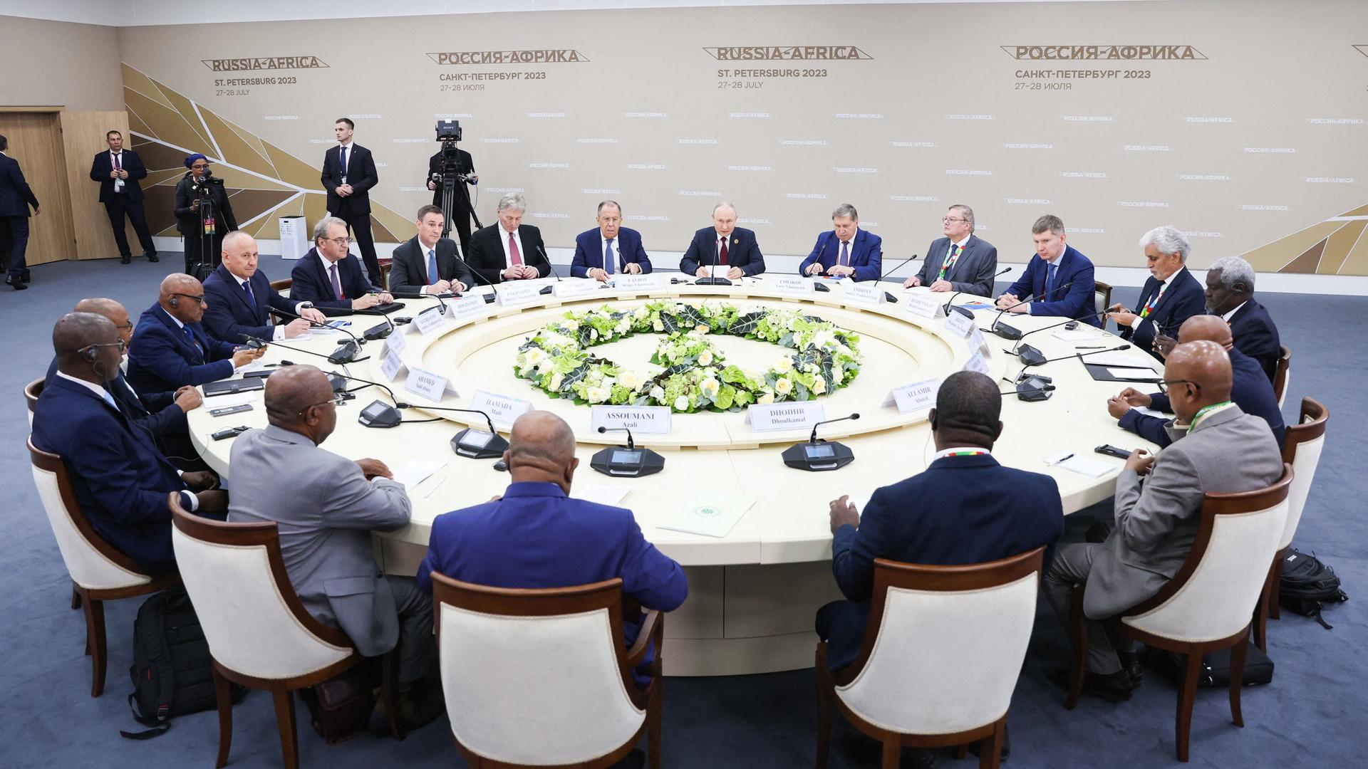Präsident Putin sitzt mit Teilnehmern des Russland-Afrika-Gipfels an einem runden Tisch.