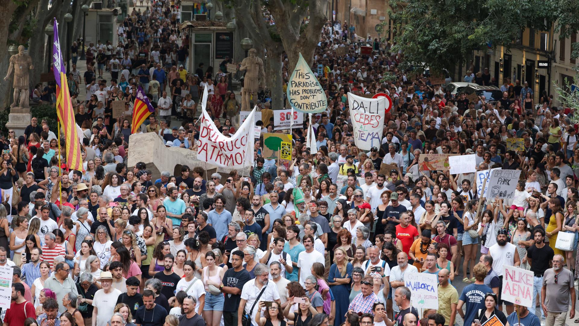 In Palma de Mallorca demonstrieren tausende Menschen gegen den Massentourismus. Aus einer dichtgedrängten Menge werden Plakate und Transparente in die Höhe gehalten. 