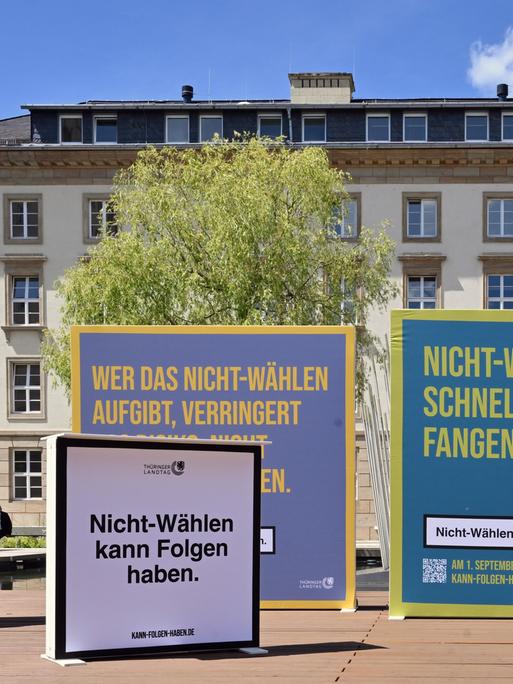 Plakate einer Kampagne zur Wahlmobilisierung. Auf dem Vordersten steht im Stil des Warnhinweises auf einer Zigarettenschachtel: "Nicht-Wählen kann Folgen haben."