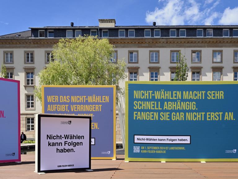 Plakate einer Kampagne zur Wahlmobilisierung. Auf dem Vordersten steht im Stil des Warnhinweises auf einer Zigarettenschachtel: "Nicht-Wählen kann Folgen haben."