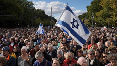 Menschen schwenken israelische Flaggen während einer Demonstration gegen Antisemitismus und für Solidarität mit Israel in Berlin