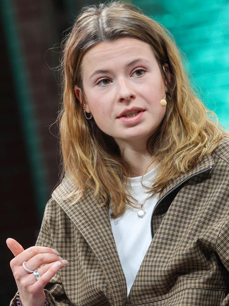 Luisa Neubauer auf Bühne der der Konferenz Re:publica in Berlin. Sie schaut leicht zur Seite, vor ihrem Mund ein Bügelmikrofon. Der Hintergrund schimmert grünlich.