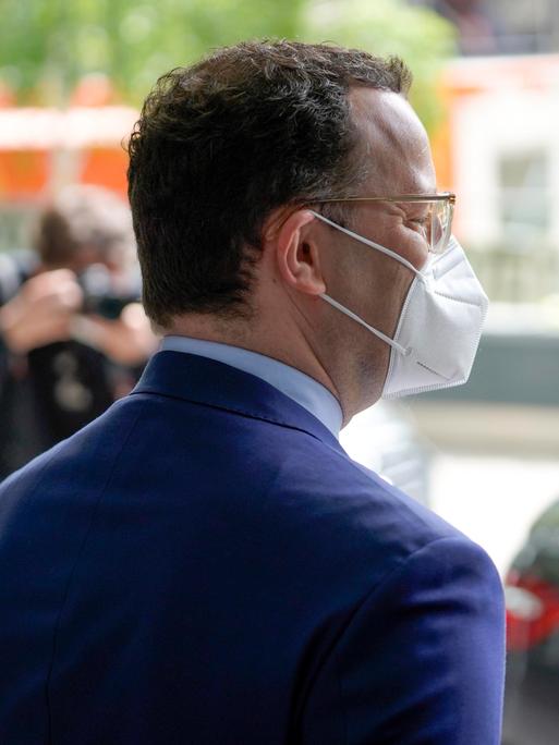 Der ehemalige Bundesgesundheitsminister Jens Spahn steht mit dem Rücken zur Kamera gedreht und trägt einen Mundschutz.