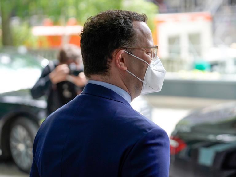 Der ehemalige Bundesgesundheitsminister Jens Spahn steht mit dem Rücken zur Kamera gedreht und trägt einen Mundschutz.