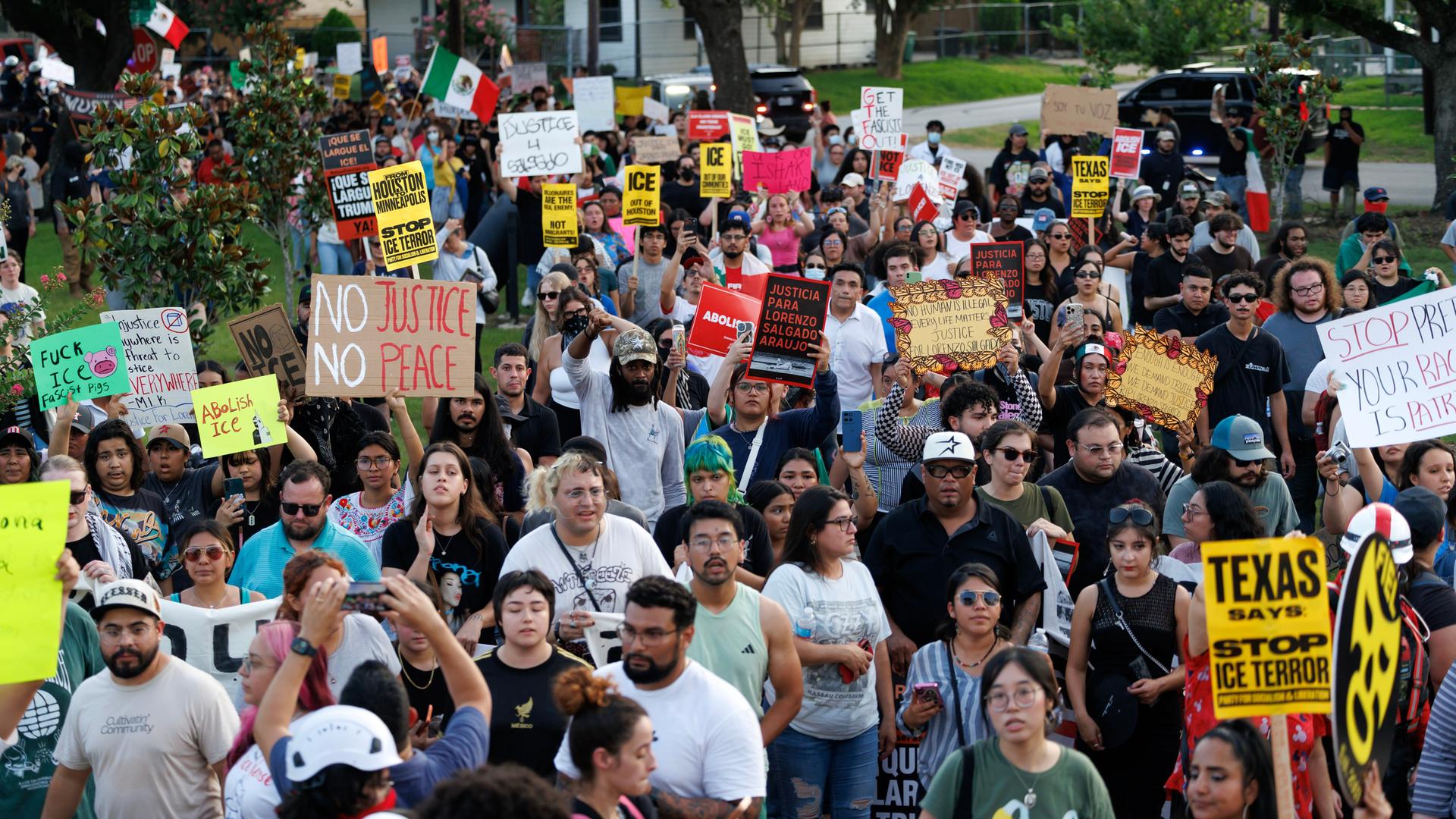 Viele Menschen mit Plakaten laufen protestierend durch die Straßen von Houston.