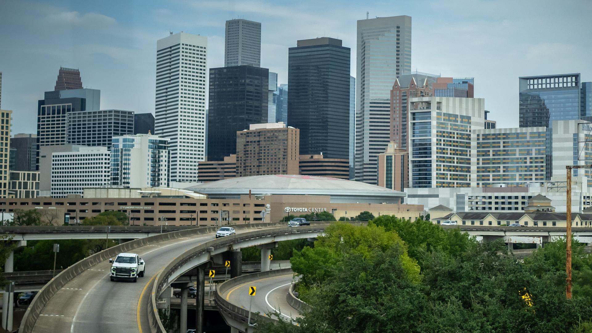 Blick auf die Skyline mit den Hochhäusern von Houston im US-Bundesstaat Texas. Im Vordergrund eine Brücke mit Autos darauf, im Hinergrund viele Hochhäuser. Blick auf die Skyline mit den Hochhäusern von Houston im US-Bundesstaat Texas. Im Vordergrund eine Brücke mit Autos darauf, im Hinergrund viele Hochhäuser.
