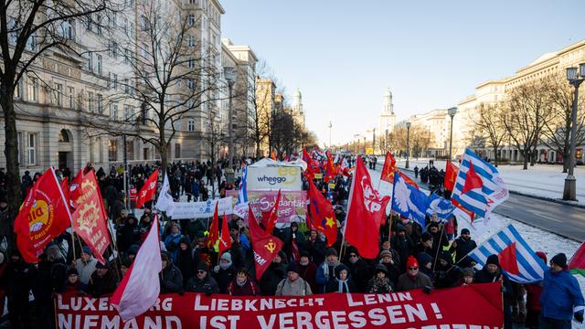 Teilnehmer halten während der Demonstration "Luxemburg-Liebknecht-Ehrung 2026" im Gedenken an die 1919 ermordeten Rosa Luxemburg und Karl Liebknecht Banner und Plakate.