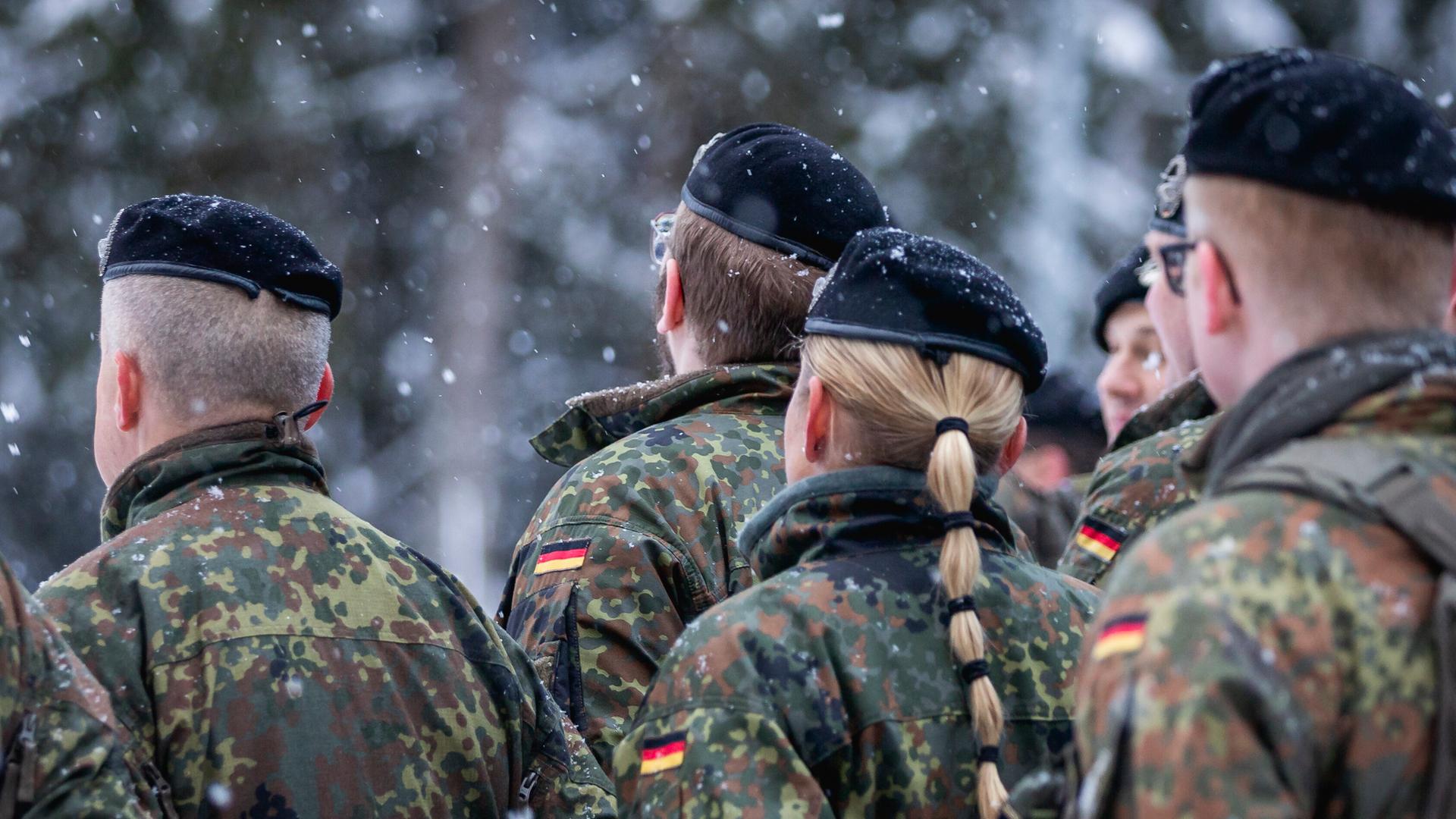 Zu sehen sind Soldatinnen und Soldaten der Bundeswehr in Uniform von hinten.