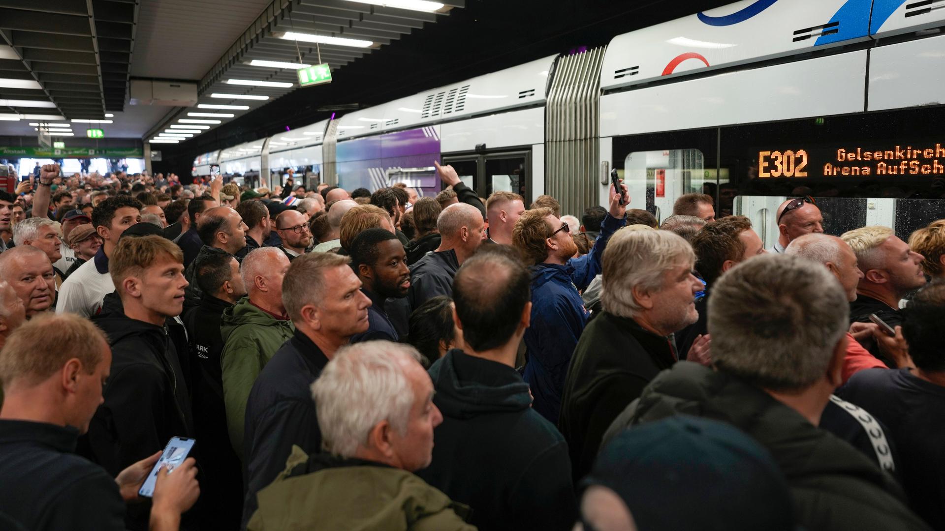 Fußballfans drängen sich auf dem Bahnsteig vor einer U-Bahn, deren Anzeigetafel das Ziel "Arena AufSchalke" angibt Fußballfans drängen sich auf dem Bahnsteig vor einer U-Bahn, deren Anzeigetafel das Ziel "Arena AufSchalke" angibt