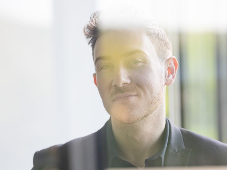 Porträt von Tristan Horx bei dem sich Spiegelungen auf seinem Abbild einzeichnen.