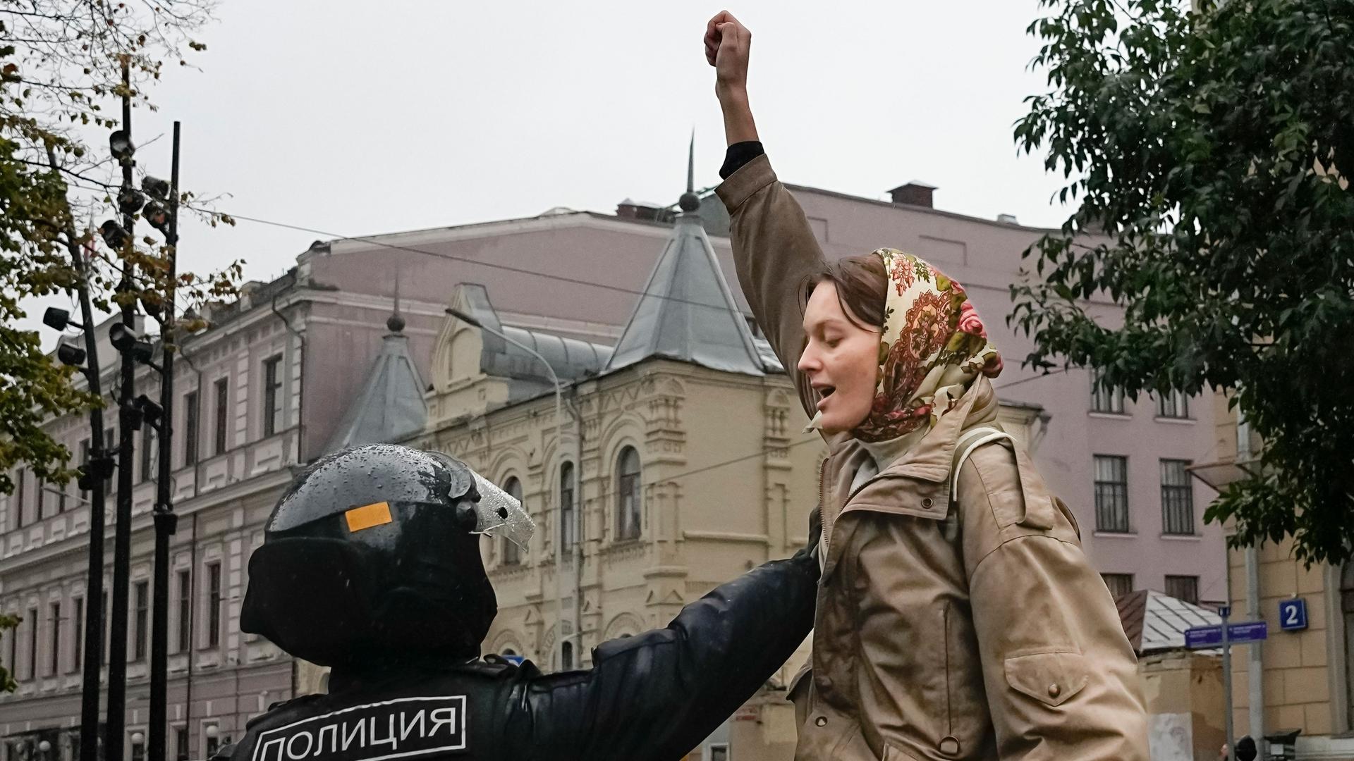 Ein Polizeibeamter hält eine Demonstrantin während einer Demonstration in Moskau gegen eine Teilmobilisierung fest. 