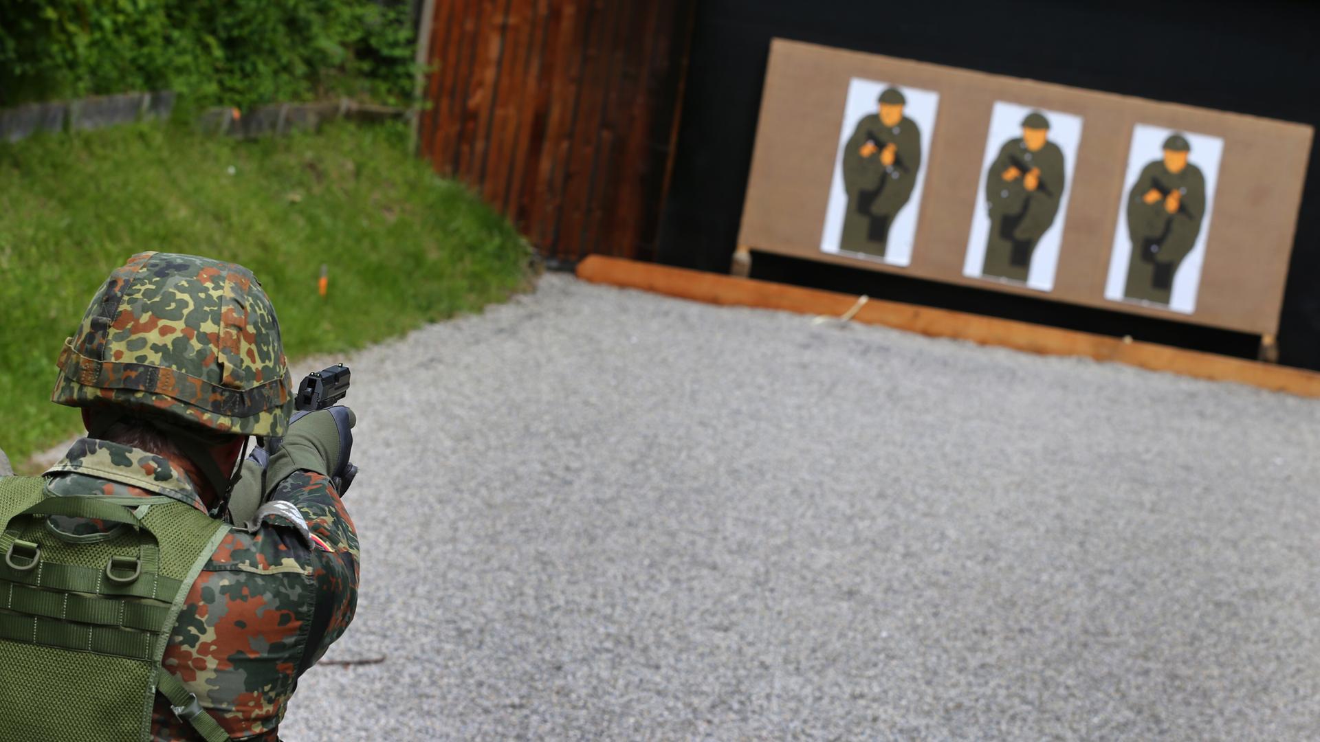 Ein Teilnehmer einer Schießübung der Bundeswehr zielt mit seiner Pistole auf zu treffende "Pappkameraden". Ein Teilnehmer einer Schießübung der Bundeswehr zielt mit seiner Pistole auf zu treffende "Pappkameraden".