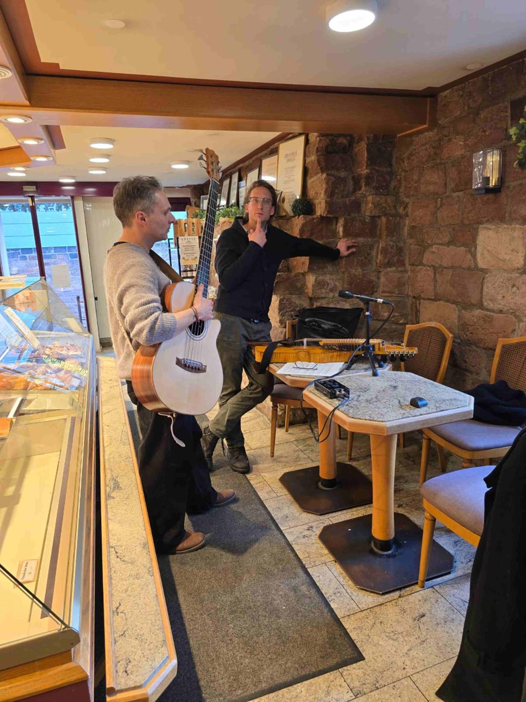 Janko Hanushevsky mit Gitarre und Nathan Bontrager in einer Bäckerei (Backstube Beissel in Eberbach)