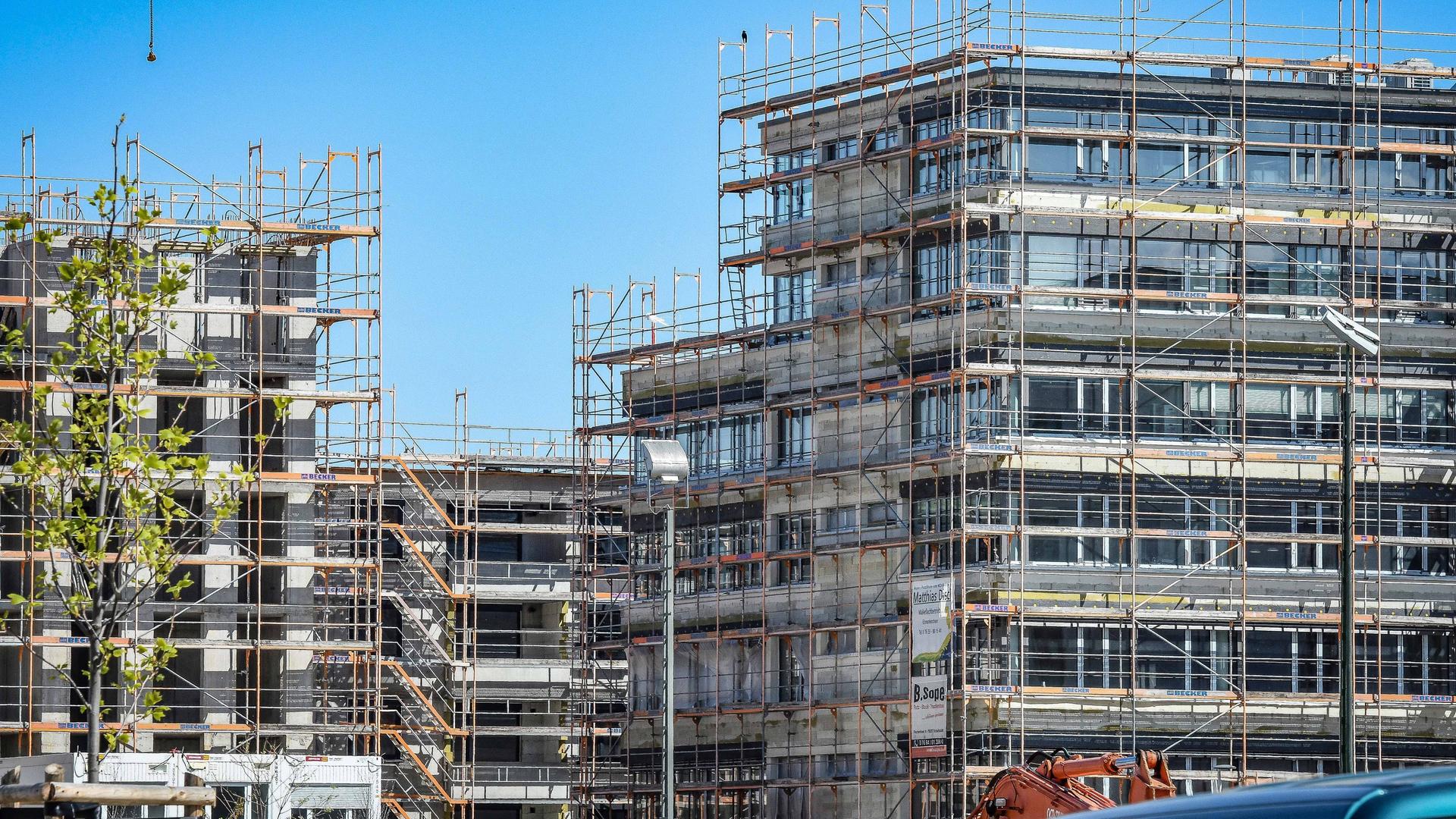 Wohnungsneubau in Freiburg: Es ist eine Baustelle mit mehreren eingerüsteten Häusern zu sehen. 