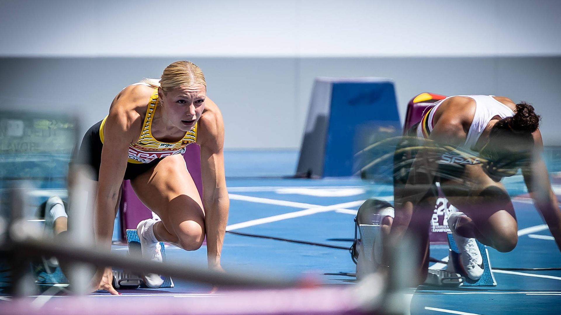 Die deutsche Sprinterin Lisa Mayer (l.) kniet vor einem Sprint im Startblock