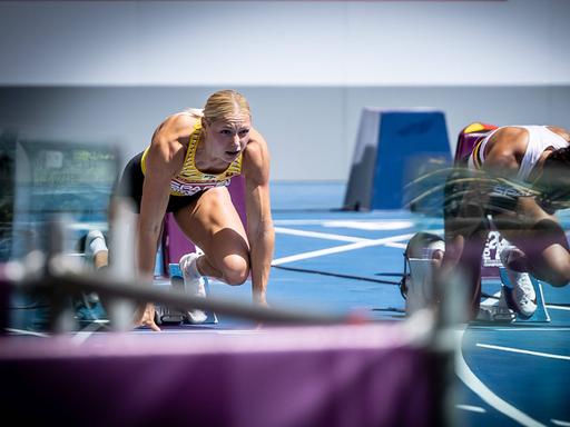 Die deutsche Sprinterin Lisa Mayer (l.) kniet vor einem Sprint im Startblock