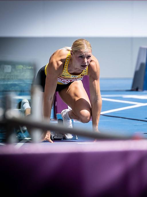 Die deutsche Sprinterin Lisa Mayer (l.) kniet vor einem Sprint im Startblock