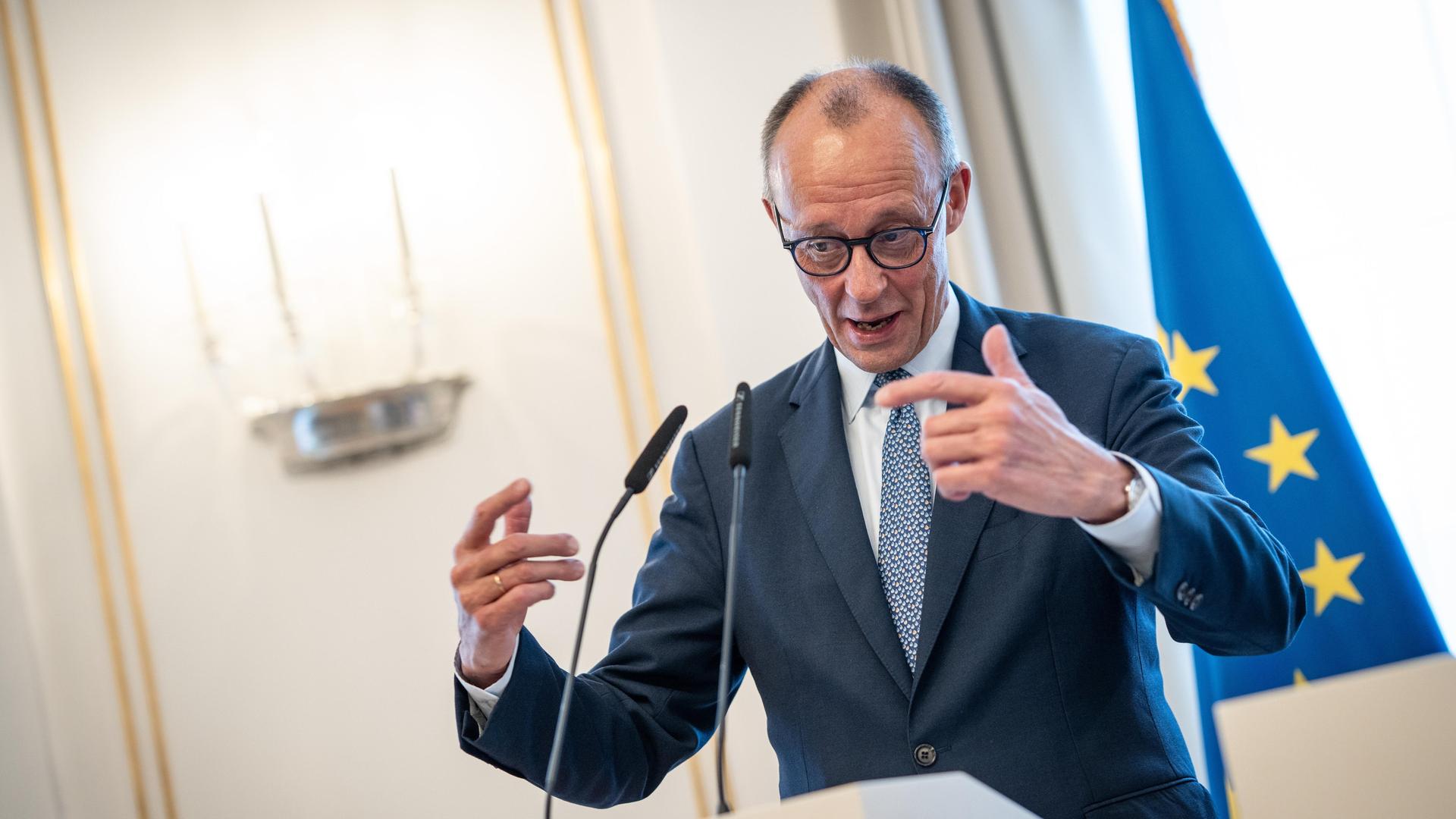 Das Bild zeigt Bundeskanzler Merz an einem Rednerpult nach einem Besuch bei der baden-württembergischen Landesregierung in Stuttgart. 