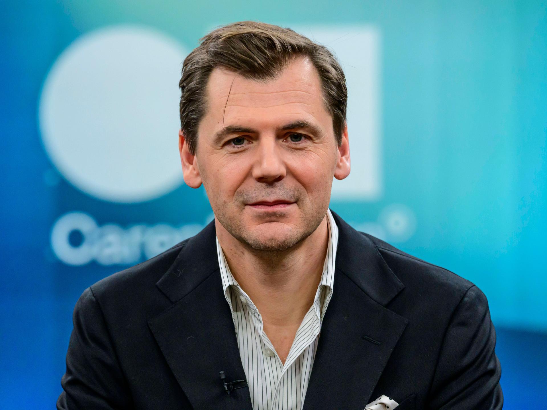 Der Autor, Publizist und Islamwissenschaftler Daniel Gerlach. Er schaut in die Kamera. Er trägt ein weiß gestreiftes Hemd und eine dunkle Jacke. 