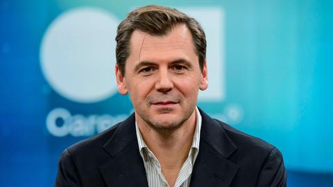 Der Autor, Publizist und Islamwissenschaftler Daniel Gerlach. Er schaut in die Kamera. Er trägt ein weiß gestreiftes Hemd und eine dunkle Jacke. 