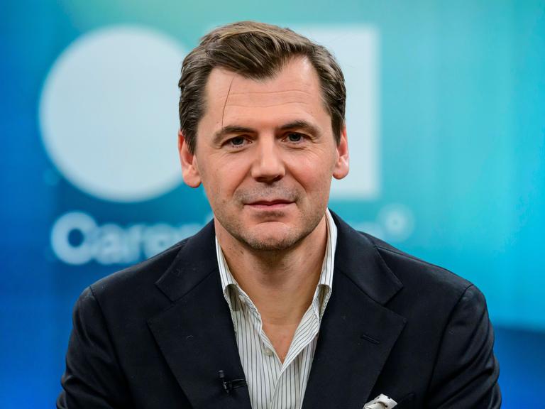 Der Autor, Publizist und Islamwissenschaftler Daniel Gerlach. Er schaut in die Kamera. Er trägt ein weiß gestreiftes Hemd und eine dunkle Jacke. 