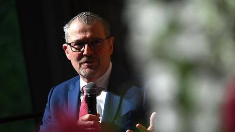 Rainer Dulger, Präsident Bundesvereinigung der Deutschen Arbeitgeberverbände spricht vor verschwommenen Hintergrund. Er hält ein Mikrofon in der rechten Hand, die linke ist geöffnet. 