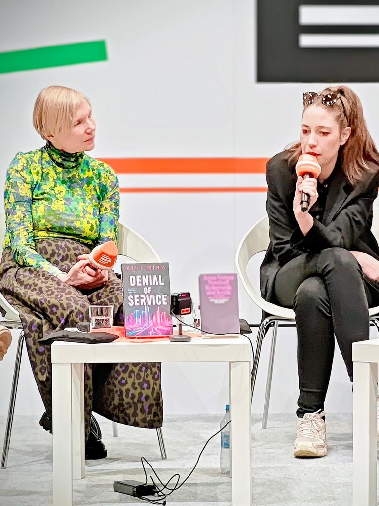 Aiki Mira, Anna-Verena Nosthoff und Veronika Kracher (v.l.n.r.) sitzen mit Dlf-Mikrofonen hinter zwei kleinen Tischen am Deutschlandradio-Stand auf der Leipziger Buchmesse und sprechen miteinander